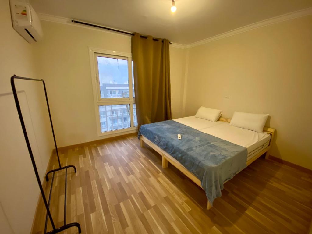Un dormitorio con una cama y una ventana grande en Relaxing stay ready Anytime Free Wifi, en Madinaty