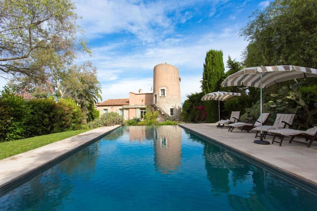 une piscine devant une maison avec un bâtiment dans l'établissement Villa Cap D'Antibes- Seafront - Swimming pool -AC, à Antibes