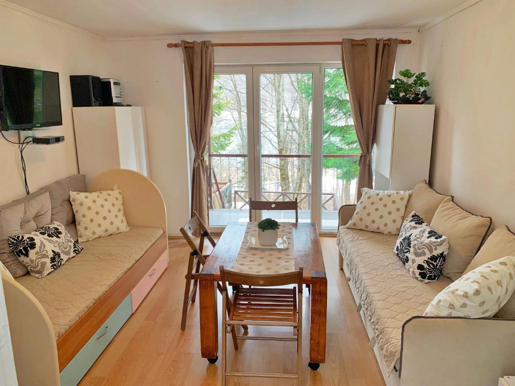 uma sala de estar com um sofá e uma mesa em Laki's House em Mavrovo