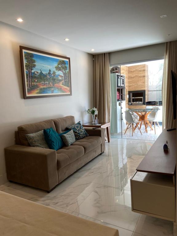 a living room with a brown couch in a room at Itapuã Beach II Espaço climatizado com piscina privativa e área gourmet! in Salvador
