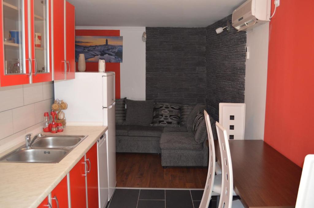 a kitchen with a refrigerator and a couch at Apartment Željko in Baška
