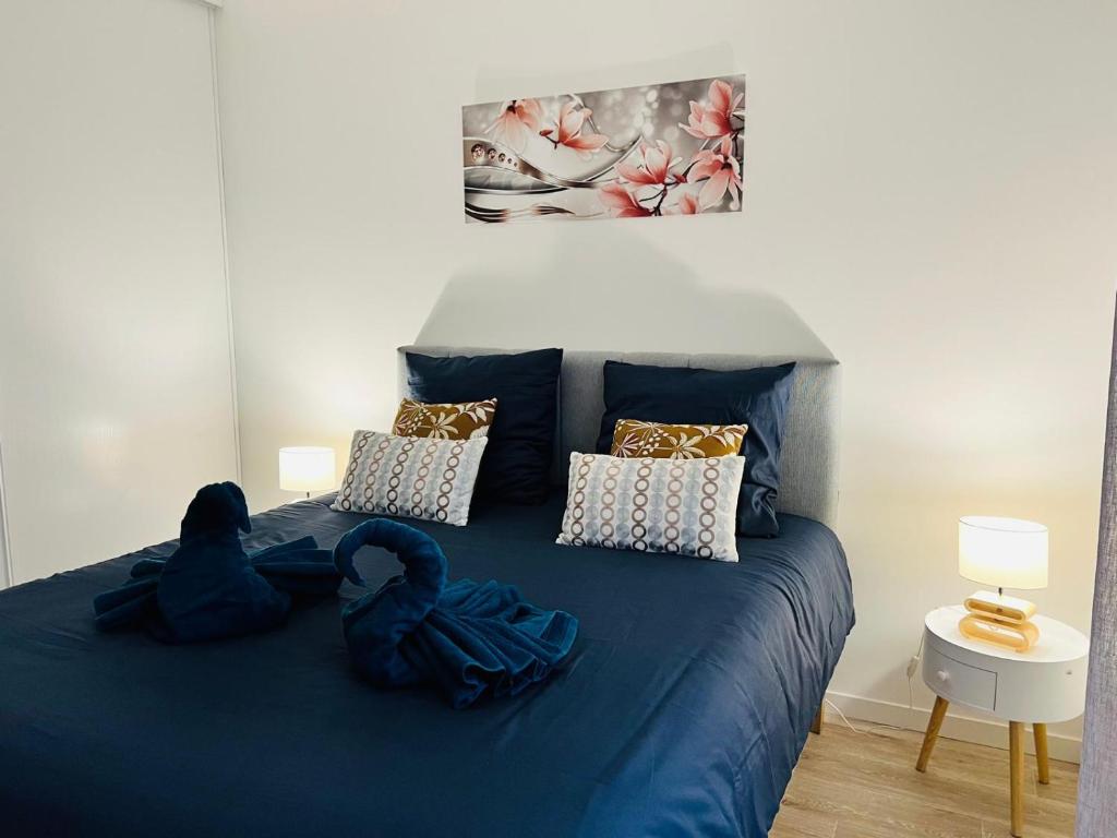 - une chambre dotée d'un lit bleu avec des draps et des oreillers bleus dans l'établissement Appartement Cosy Disneyland, à Montévrain