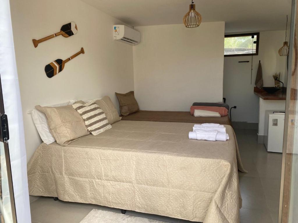 a bedroom with a large bed with two towels on it at Suites Frente ao Mar in Prado