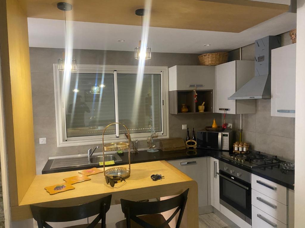 a kitchen with a table and some chairs in it at luxe et confort appartement Sahloul 4 in Sousse