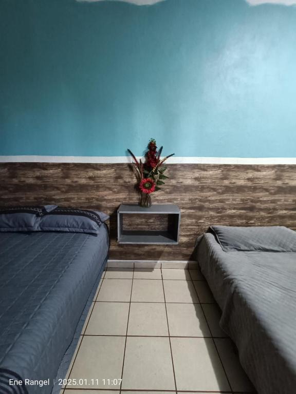a bedroom with two beds and a plant on the wall at Casa Cartagena in Zamora de Hidalgo