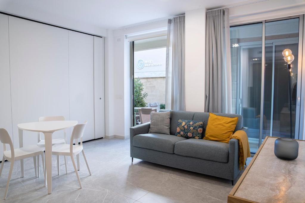 een woonkamer met een bank en een tafel bij Appartamento Guglielmo in Oristano