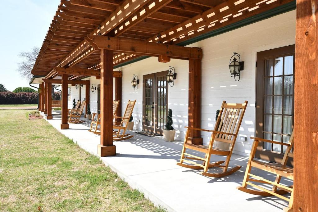 a row of rocking chairs on a porch of a house at The Manor House in Kingston