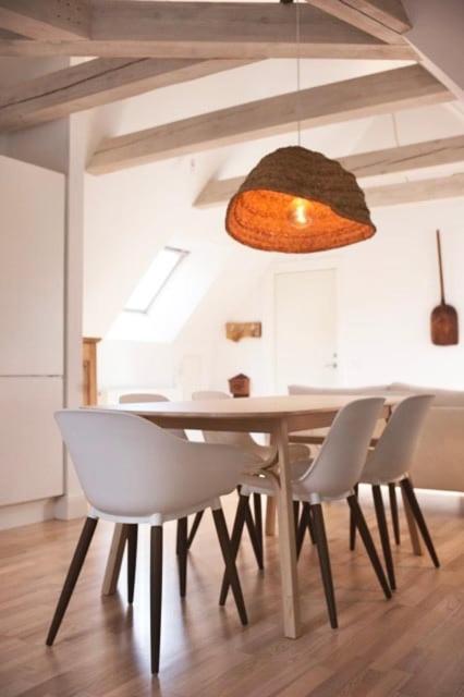 a dining room table with white chairs and a light fixture at Visby innerstad St Hans in Visby