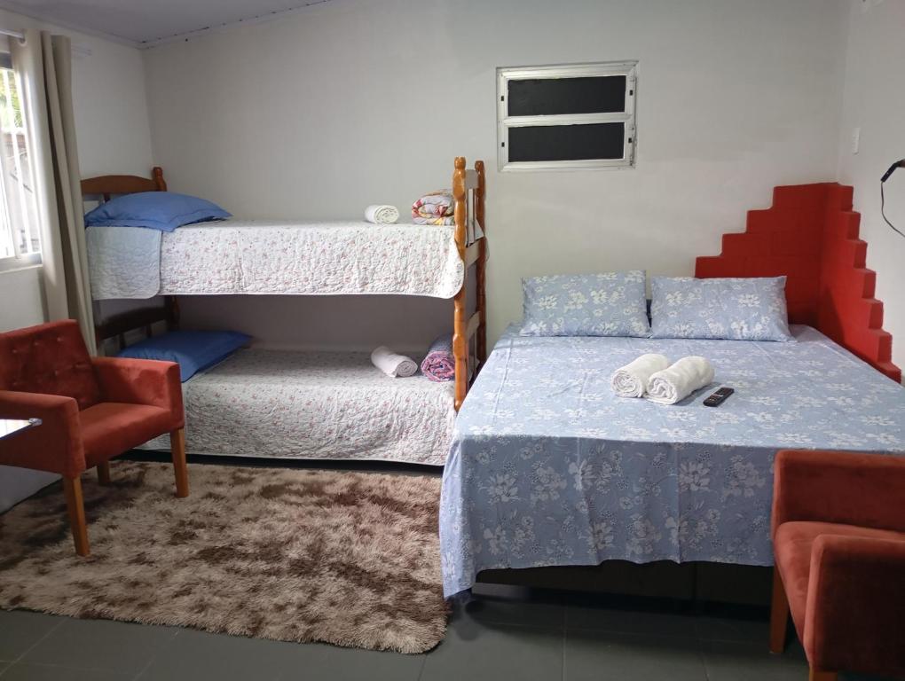 a bedroom with two bunk beds and a chair at Casa em Penha in Penha