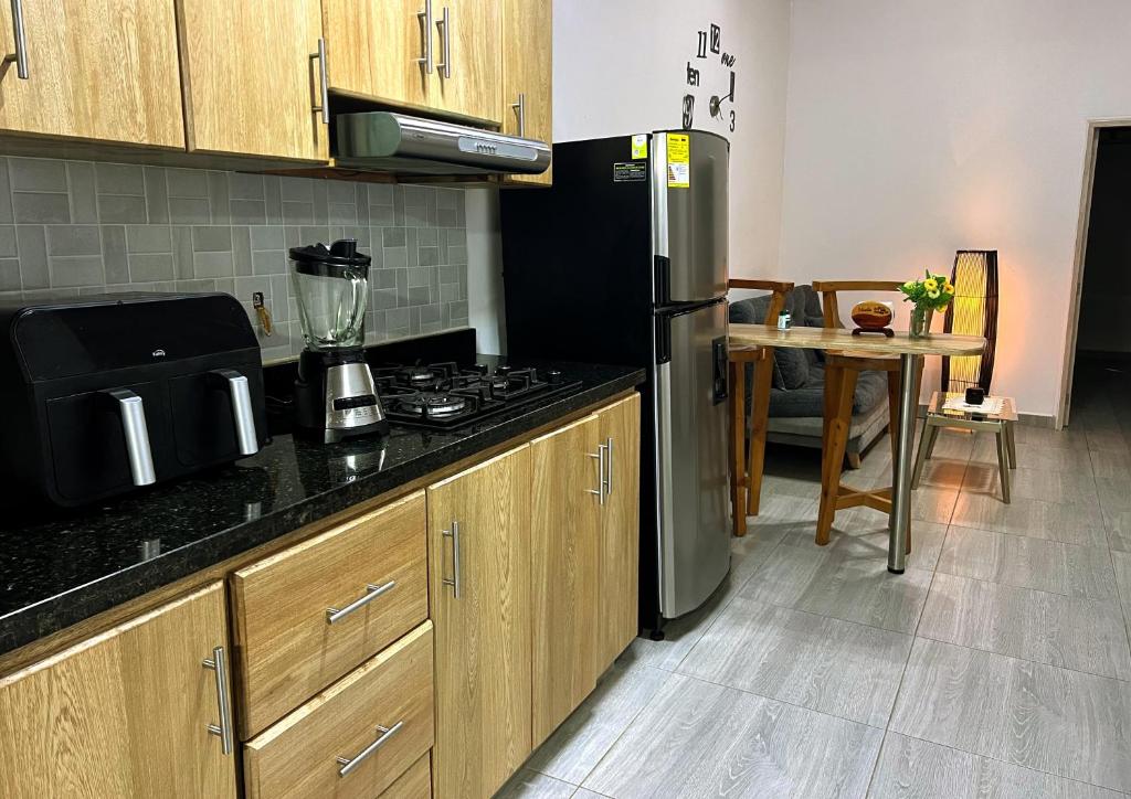 a kitchen with a stainless steel refrigerator and a table at Apartamento Guatapé Plaza in Guatapé