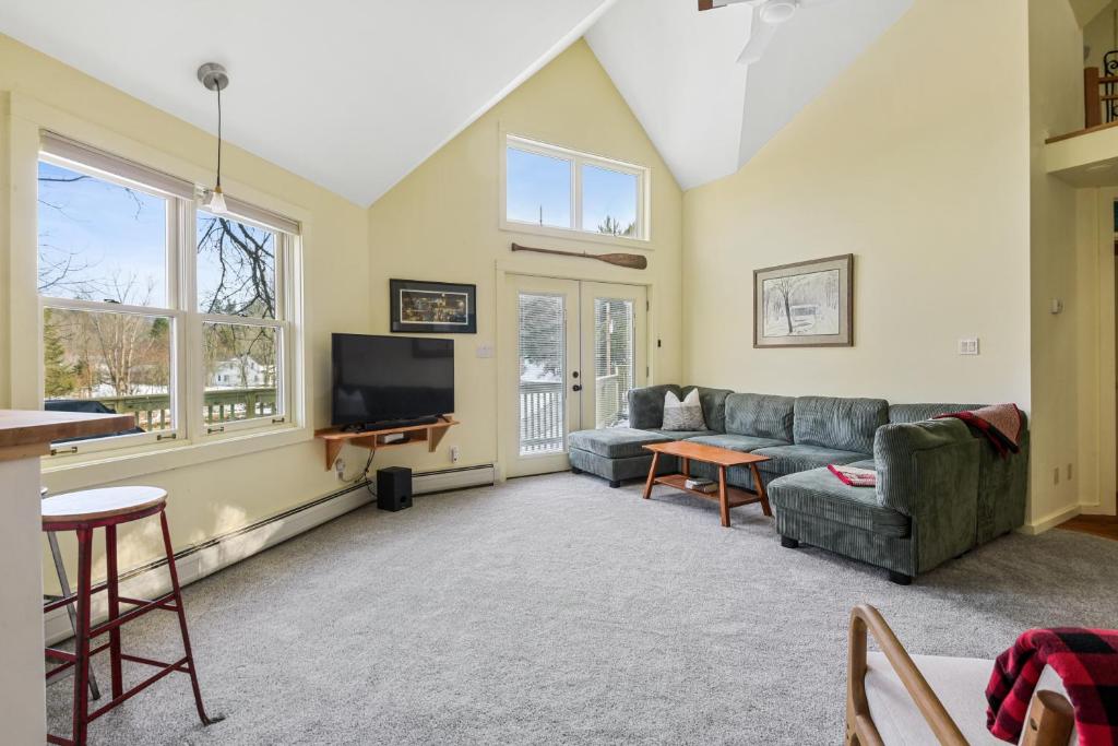 ein Wohnzimmer mit Sofa und Fernseher in der Unterkunft Tubing, Hiking and Jay Peak fun at the Cliff House in Montgomery