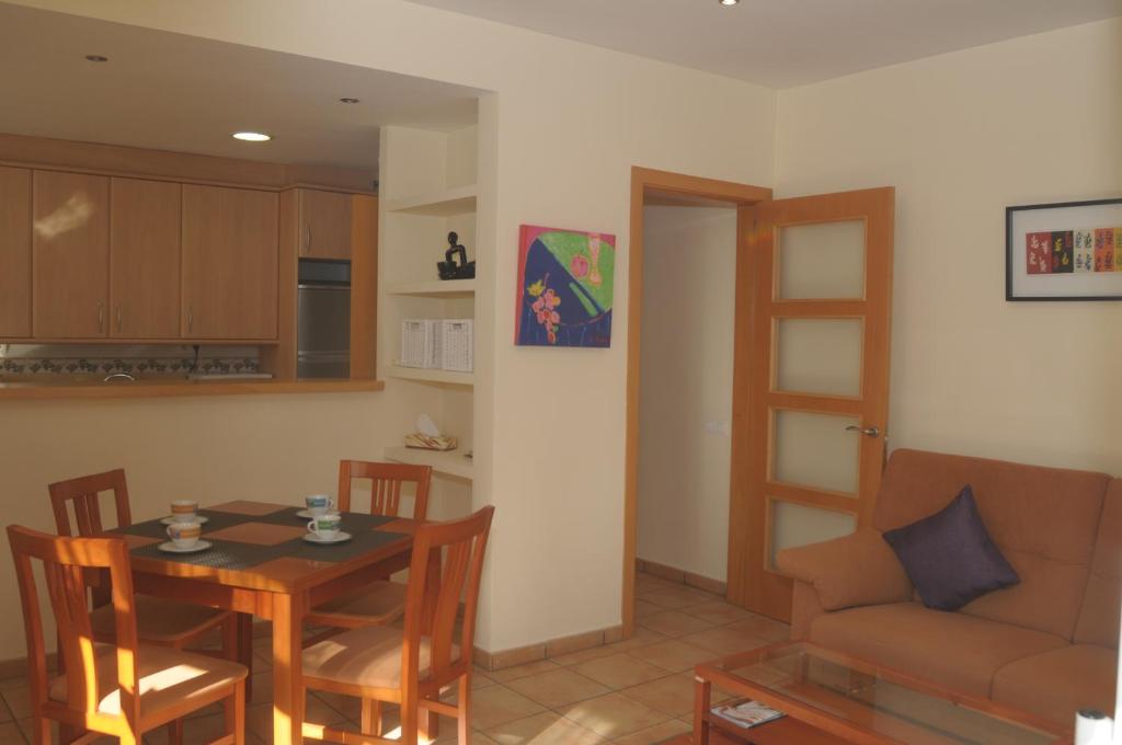 cocina y comedor con mesa y sofá en Apartaments Villa Conchi, en Sitges