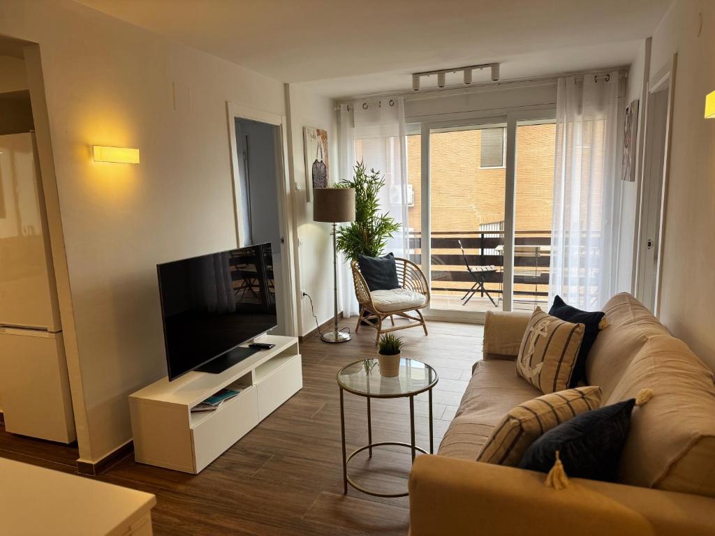 ein Wohnzimmer mit Couch und Flachbildfernseher in der Unterkunft Apartamento de 2 habitaciones en primera línea con vistas al mar in Platja de l'Arenal