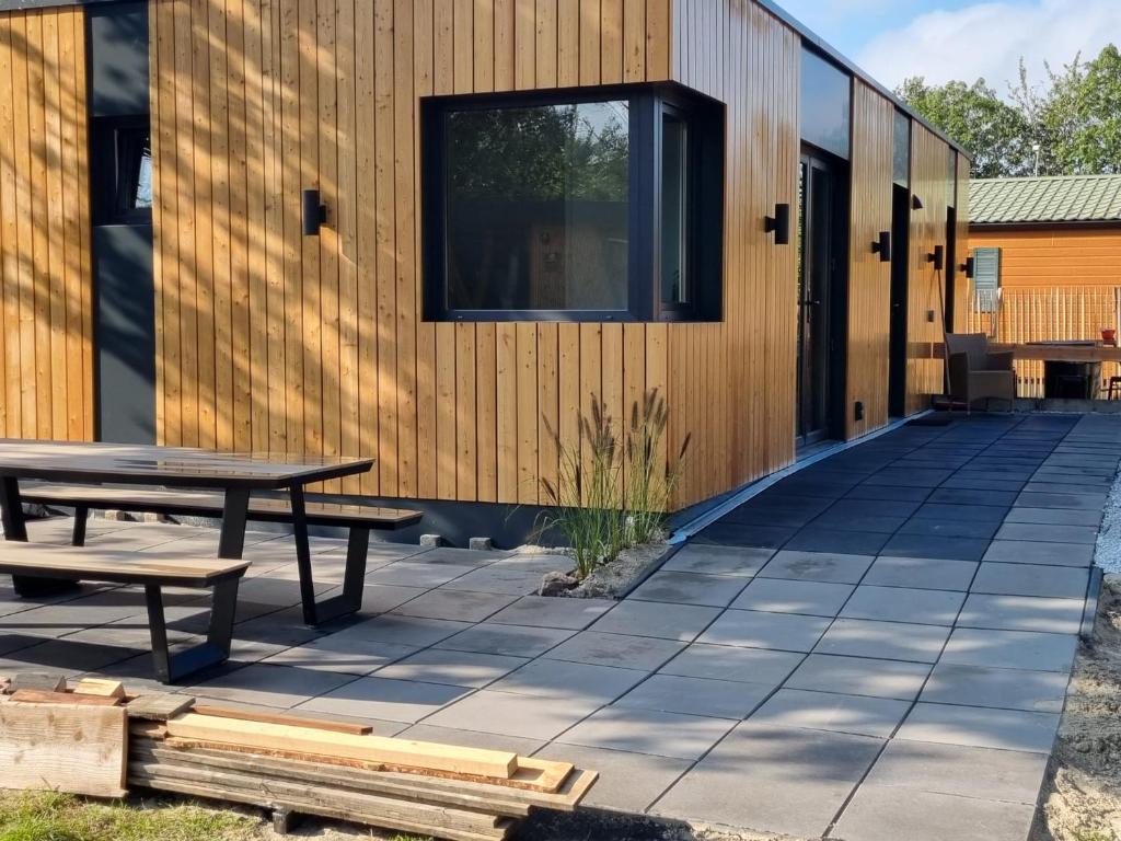 a building with a picnic table on a patio at "Chalet Zanna" privéaccomodatie op park, begaafdzorgtse in Opende