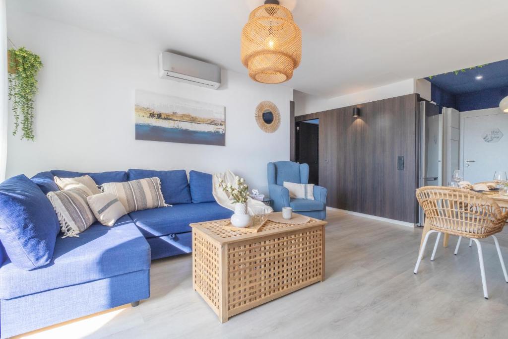 Una sala de estar con un sofá azul y una mesa. en Apartamento Dream View Aguadulce, en Aguadulce
