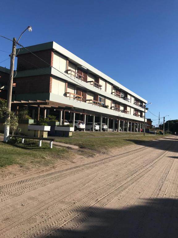 a large building with cars parked in front of it at Departamentos frente al mar-Villa Gesell in Villa Gesell