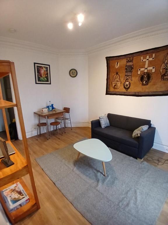 un salon avec un canapé et une table dans l'établissement Detente, à Paris
