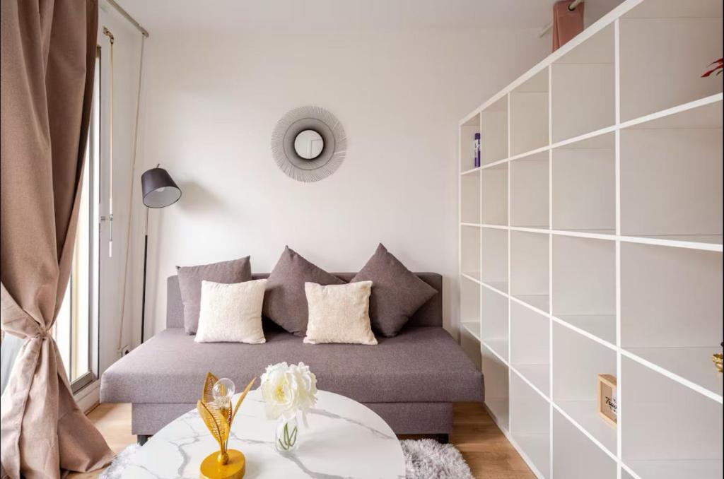 un salon avec un canapé et une table dans l'établissement Bonito apartamento cerca De la Torre Eiffel, à Paris
