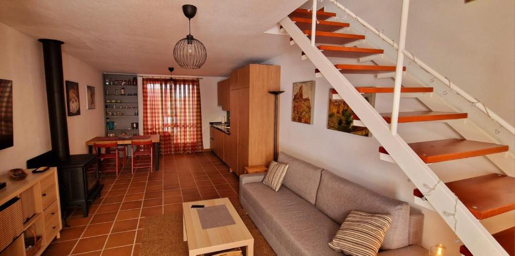 ein Wohnzimmer mit Treppe und Couch in der Unterkunft Casa en El Pedroso de tres habitaciones in El Pedroso