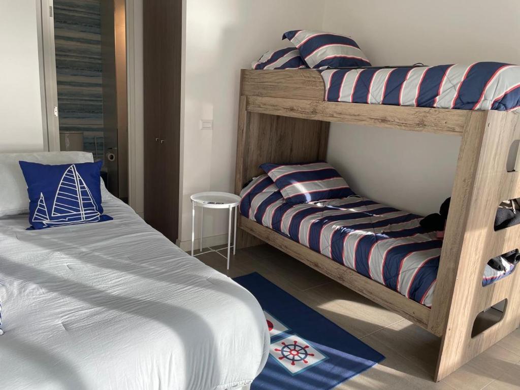 ビーニャデルマールにあるDepartamento en Concón, sector Costa de Montemarのベッドルーム1室(二段ベッド2台、スツール付)