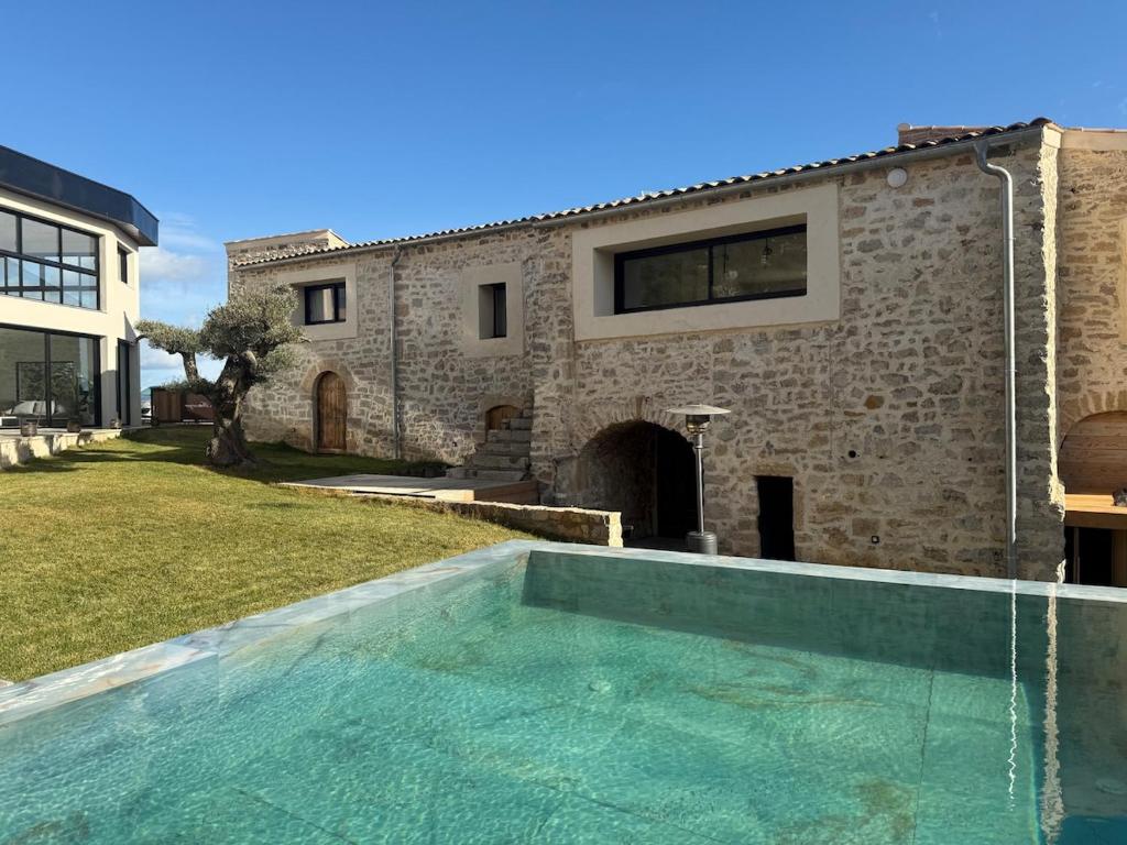 une maison avec piscine devant un immeuble dans l'établissement Le Mas du Mas d' Antonegre, à Montbazin