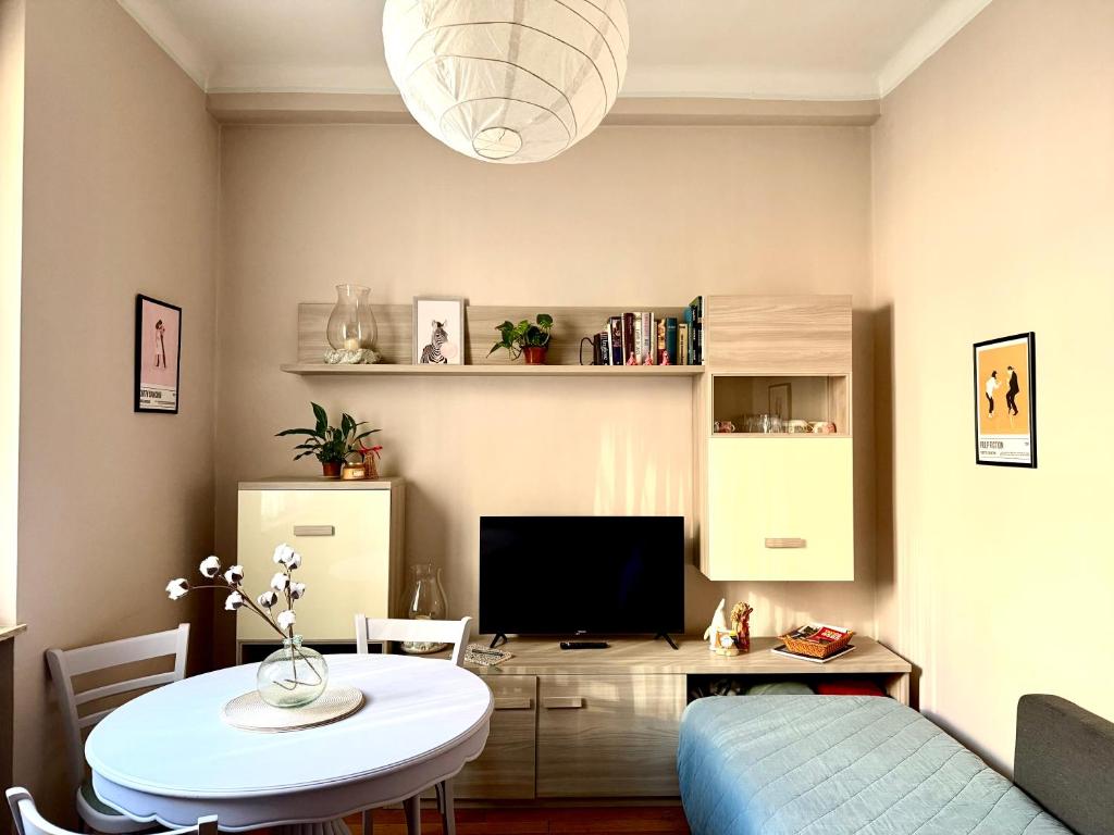a living room with a table and a television at Gionas - Casa indipendente in zona strategica in Milan