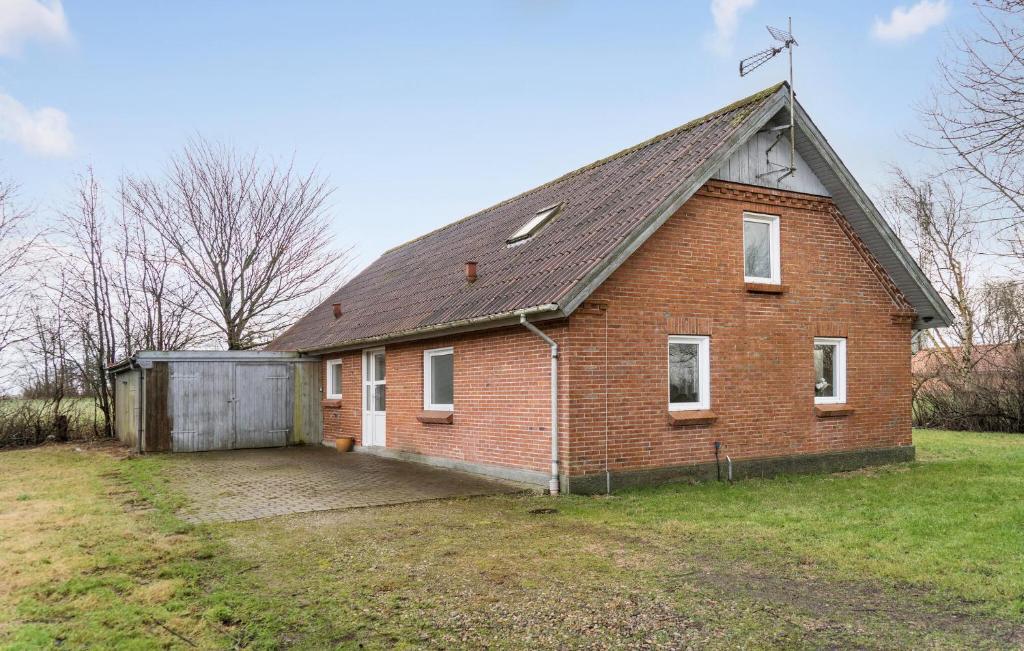 an old brick house with a garage in a yard at Awesome Home In Øster Assels With Wifi in Øster Assels