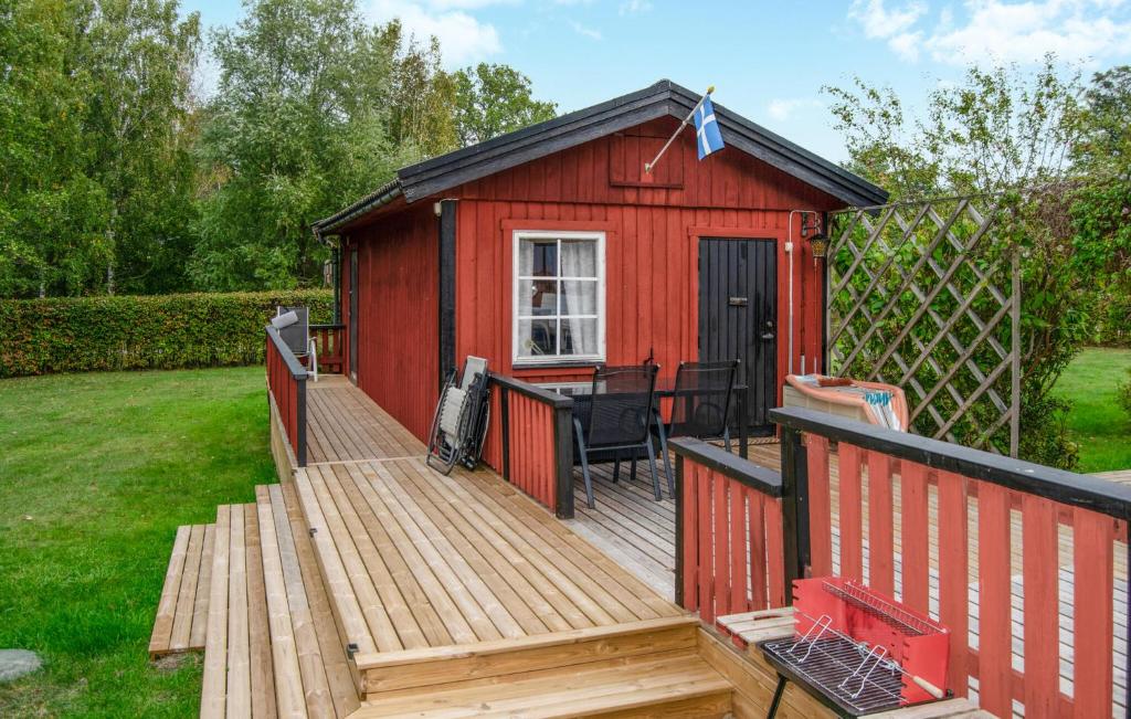 a red shed with a deck with a table at 2 Bedroom Stunning Home In Stockholm in Stockholm
