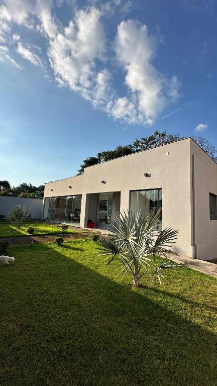 JuatubaRefúgio com Spa Jacuzzi 40 min BH的前面有棕榈树的建筑