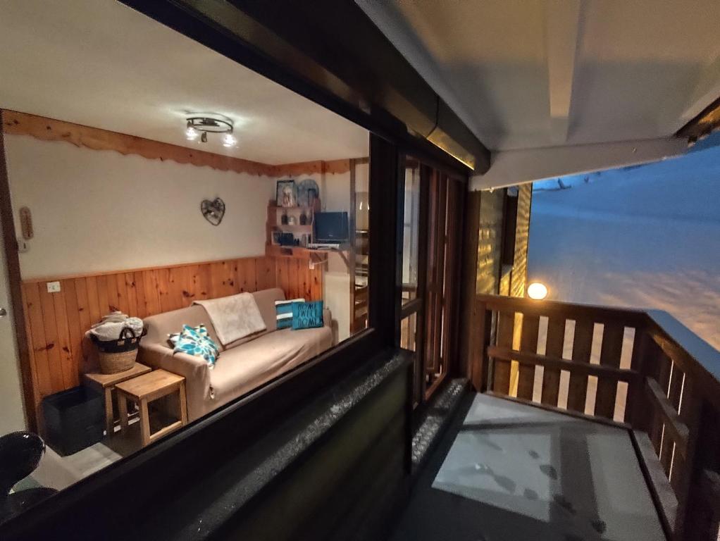 - un balcon avec vue sur le salon doté d'un canapé dans l'établissement Appartement 6 personnes au pied des pistes, à La Plagne Tarentaise