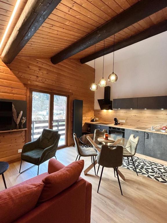 un salon avec une table et des chaises et une cuisine dans l'établissement Appartement meublé T2 le G de Gérardmer, à Gérardmer