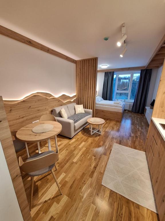a living room with a table and a couch at Apartman Vučko Dalia - Aparthotel Vučko in Jahorina