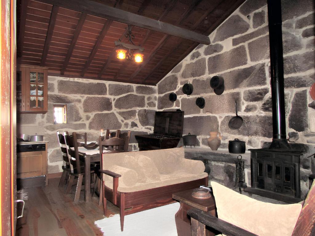 ein Wohnzimmer mit einer Steinmauer und einem Herd in der Unterkunft Charming house with fireplace, mountain view, Ponte da Barca in Pedras de Moledo