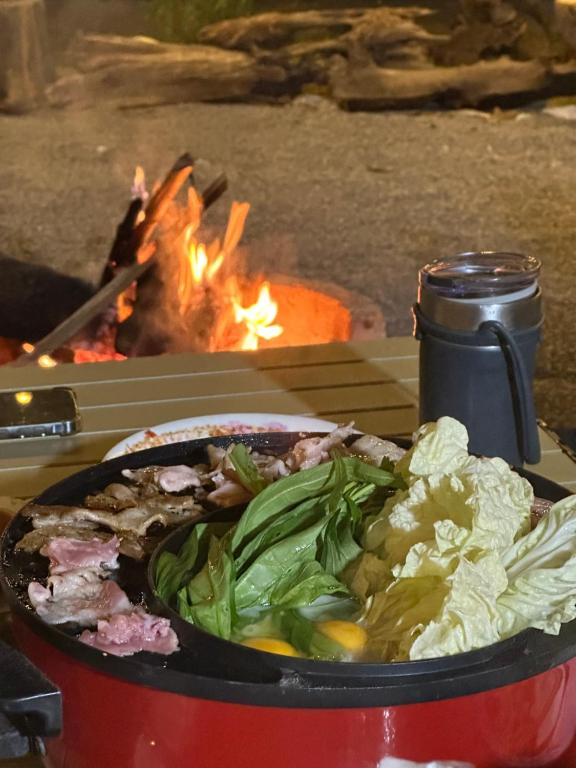 un plato de comida en una mesa junto al fuego en niti house with 2 bed room 1 bath, en Roi Et