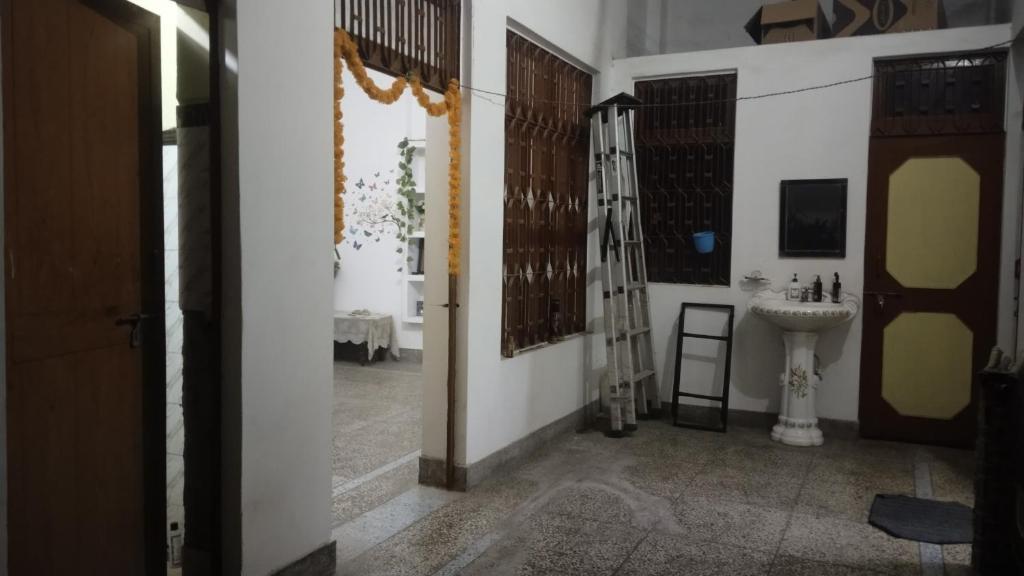 a bathroom with a sink and a ladder in a room at Prayag Homestays ADA in Prayagraj
