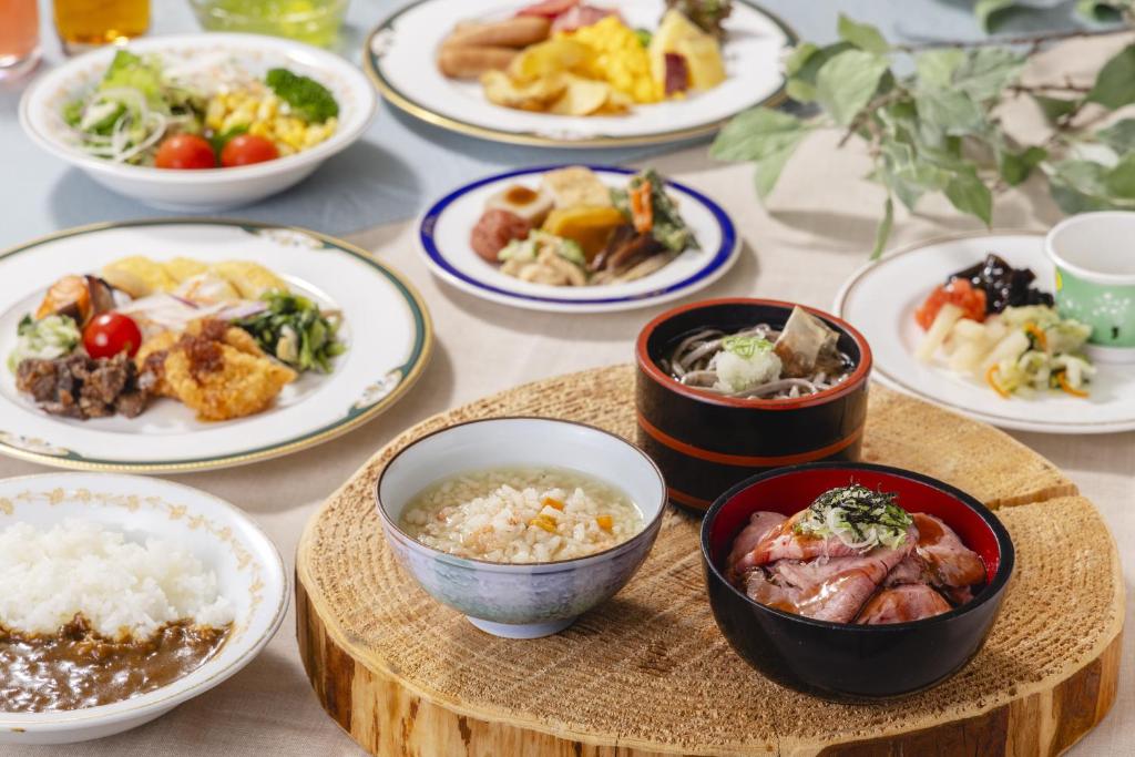 a table with plates of food and bowls of food at Hotel Fujita Fukui in Fukui