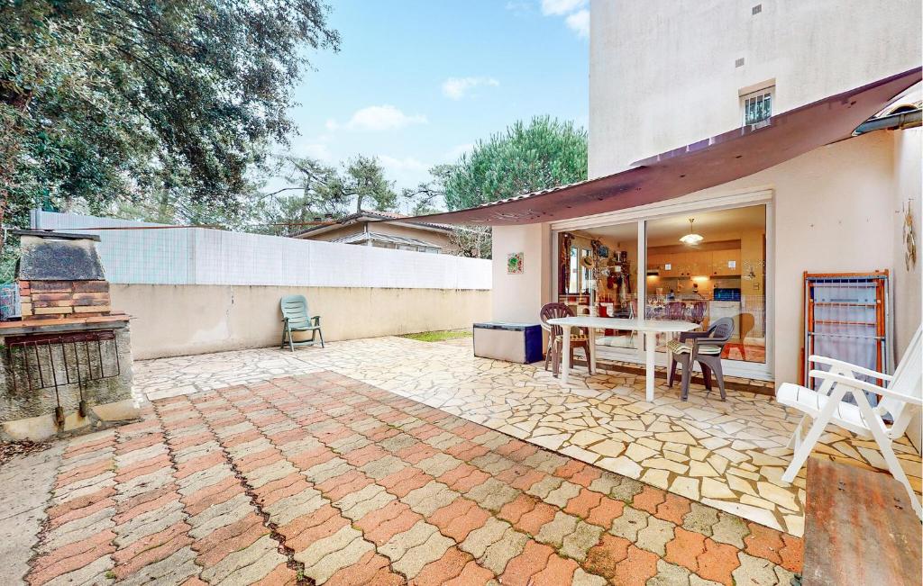 un patio extérieur avec une table et des chaises dans l'établissement Nice Home In Saint-Georges-De-Didon, à Saint-Georges-de-Didonne