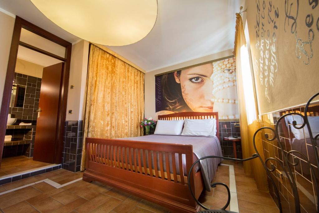 un dormitorio con una cama y una pintura de una mujer en B&B 7 Vizi, en Colà di Lazise