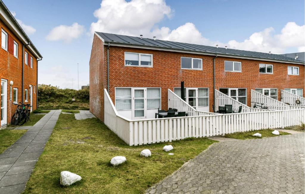 ceglany dom z białym płotem przed nim w obiekcie Nice Home In Fanø With Wifi w mieście Fanø