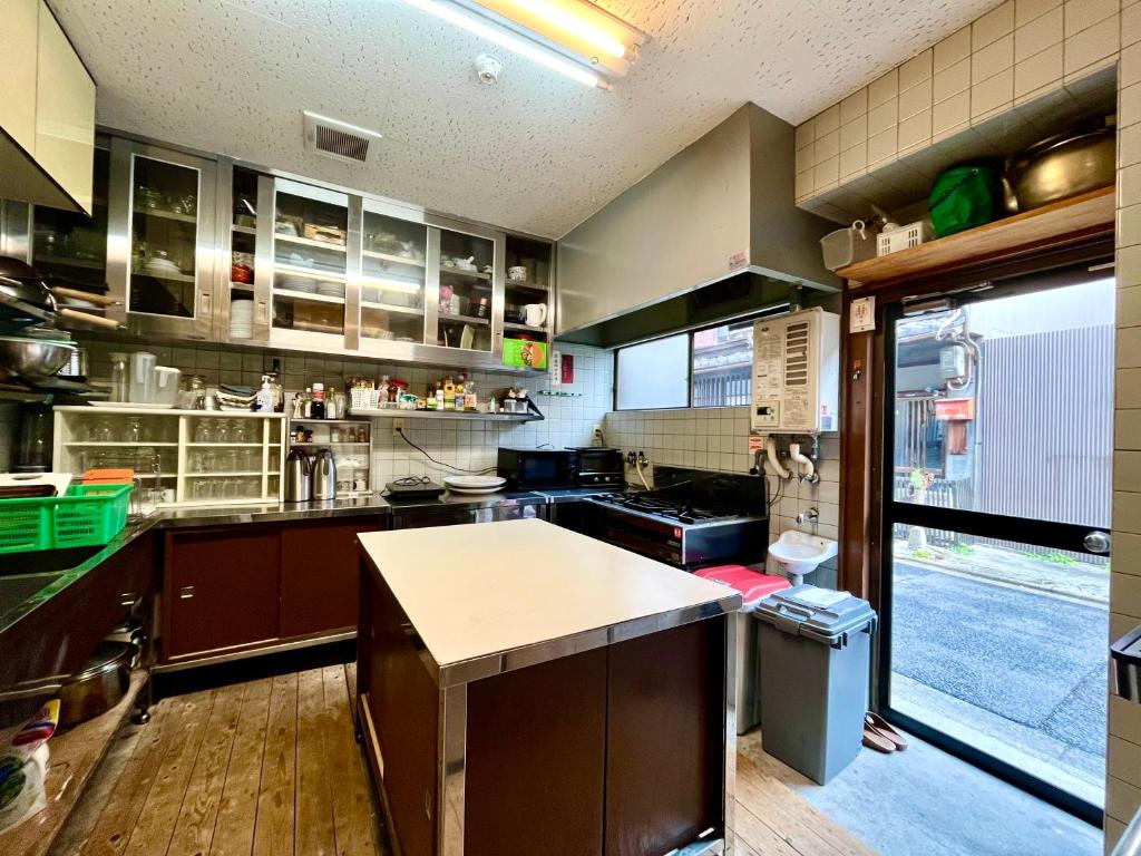 a large kitchen with a counter in the middle at Yadoya Hiraiwa private ryokan in Kyoto