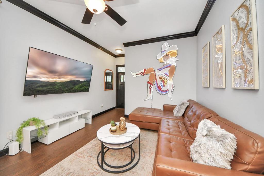 a living room with a couch and a tv at Vibrant Vegas Vibes - Hot Tub & Games - Perfect 4 Family & Groups in Houston