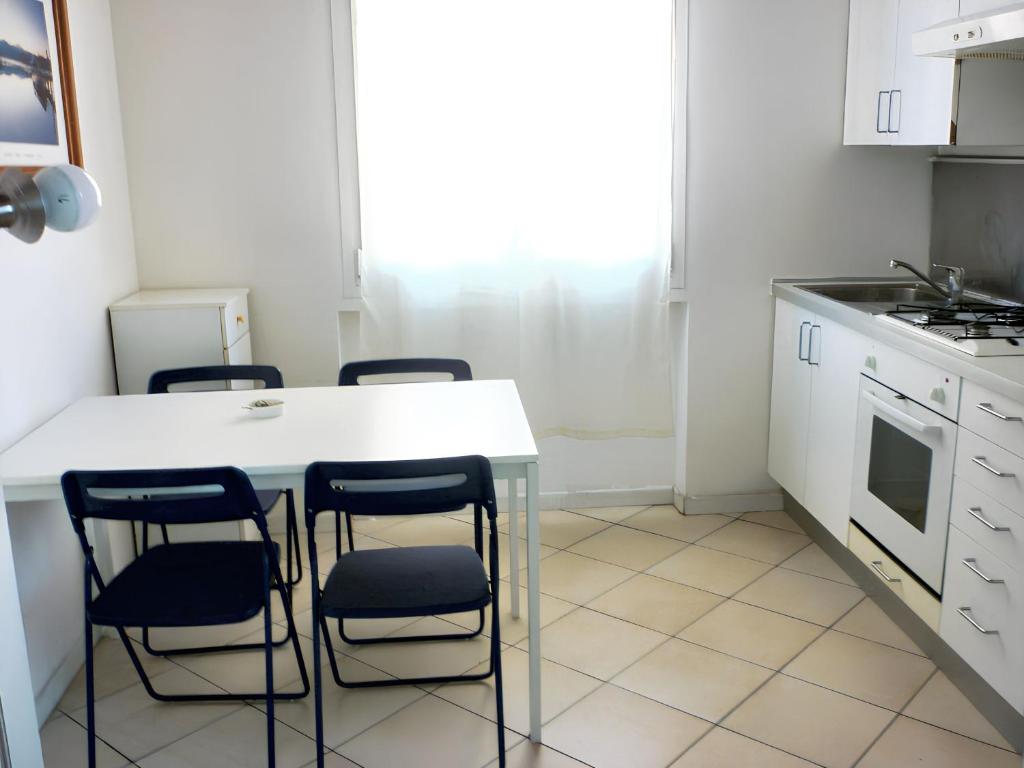 a kitchen with a table and four chairs at Cozy studio in Bologna of 45 m² with parking in Bologna