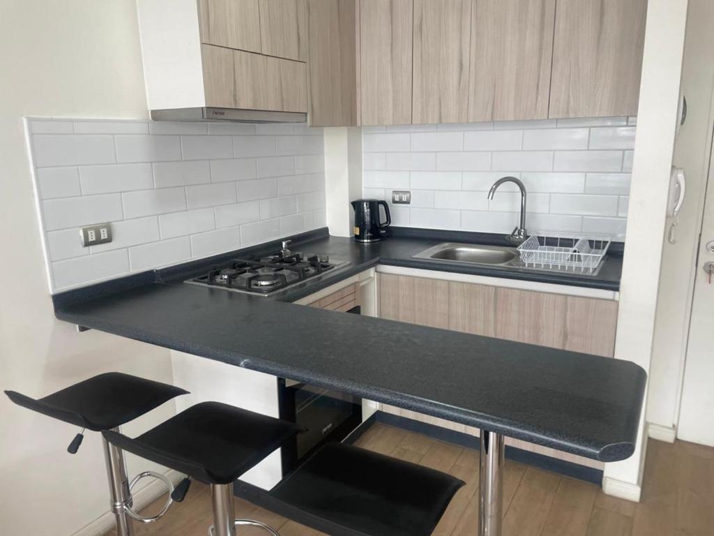a kitchen with a black counter top and a sink at Asturias La Serena in La Serena