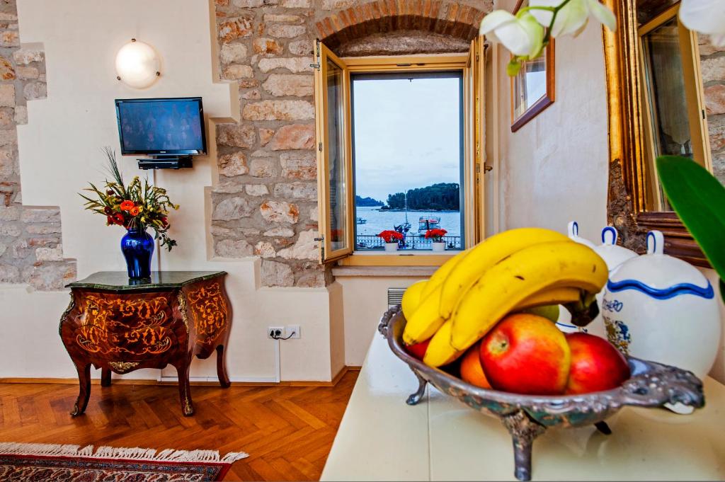 een kom bananen en appels op een aanrecht met een raam bij Residence LA CARERA Centro Storico in Rovinj