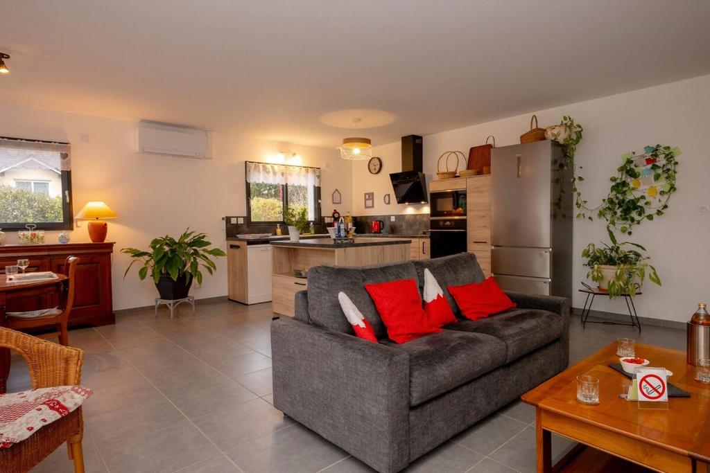 a living room with a gray couch and red pillows at Les Chaudannes in La Croix-de la Rochette