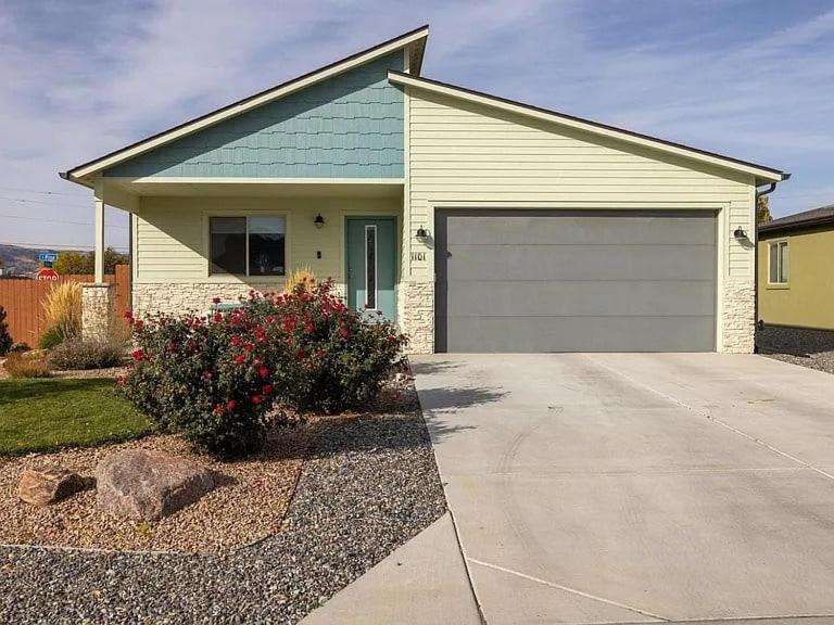 a house with a garage in front of a driveway at Bark and Bike Abode home in Fruita