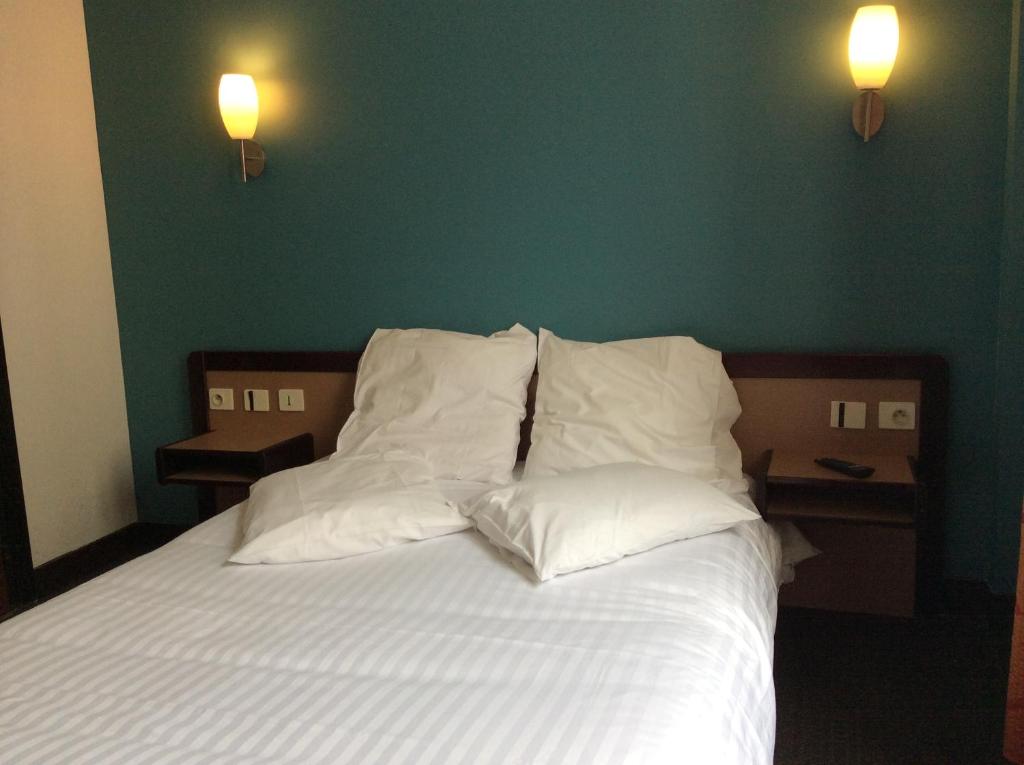 - une chambre avec un lit doté de draps et d'oreillers blancs dans l'établissement Hotel De La Place, à Malakoff