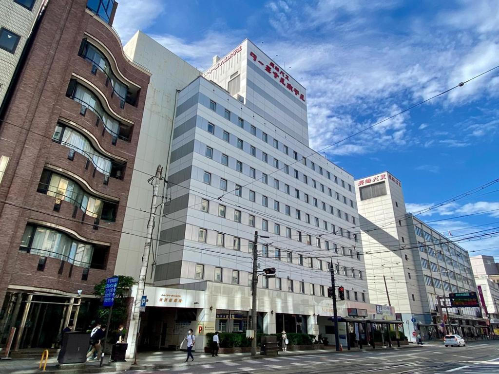 长崎Nagasaki Bus Terminal Hotel的城市街道上的一栋白色大楼