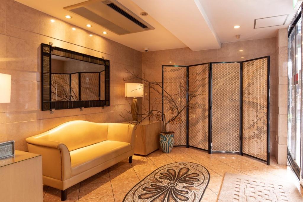 a living room with a yellow couch and a mirror at ホテルピュリッツァー自由が丘 in Tokyo