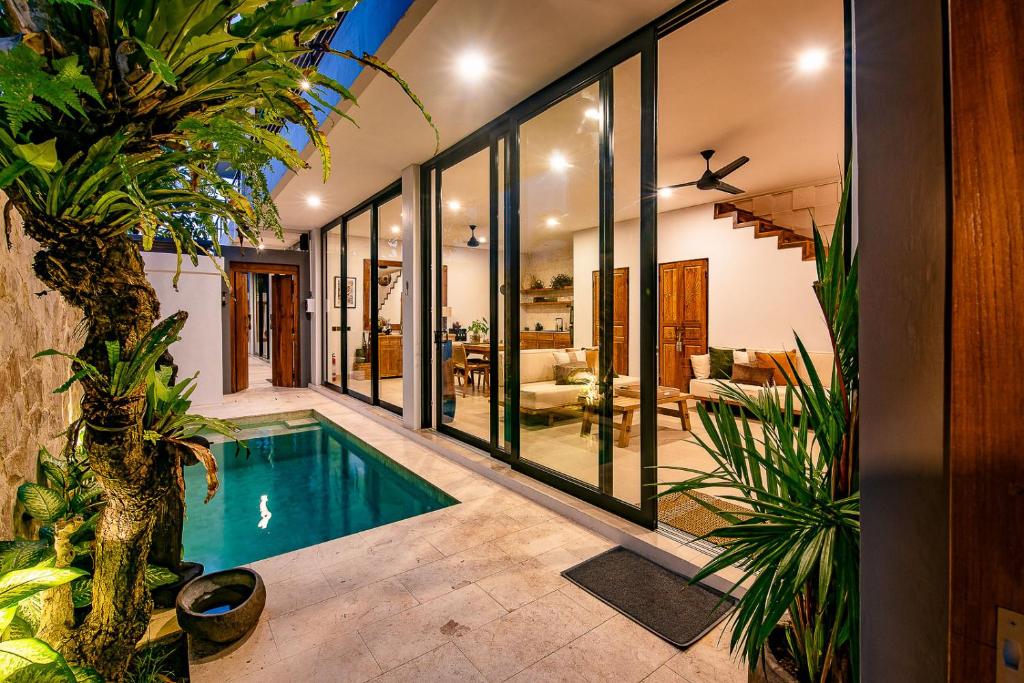 an indoor swimming pool in a house with plants at Sister Suites in Seminyak